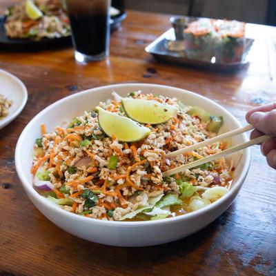 Larb Salad, a person taking some with chopsticks.