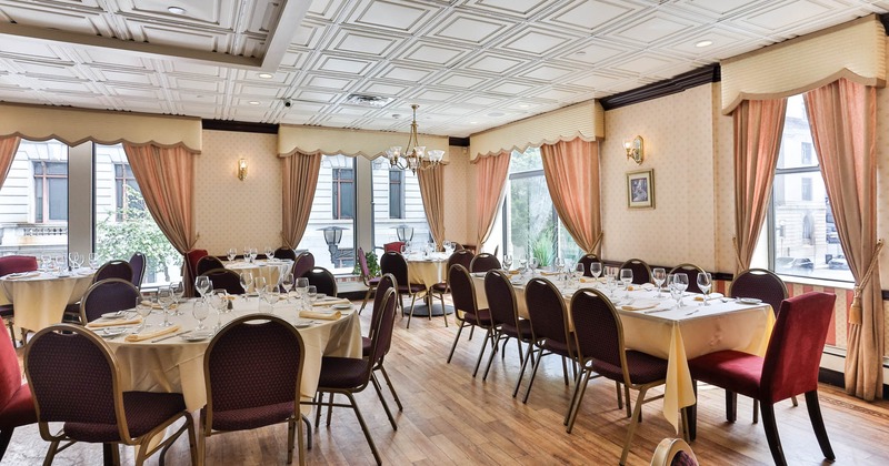 Interior, set tables with white tablecloths and burgundy chairs