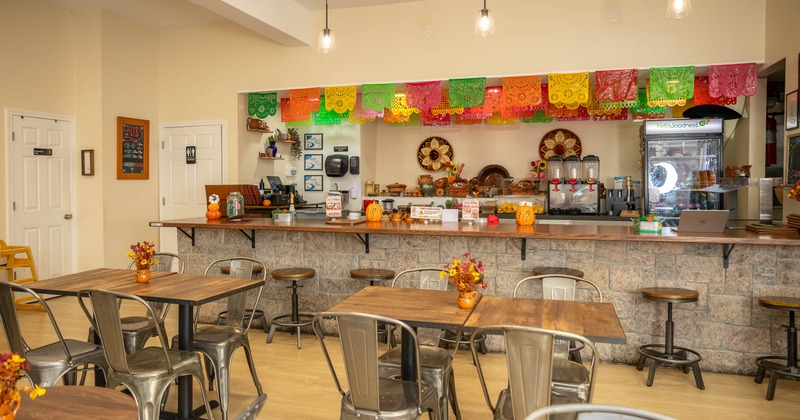 Colorful interior - tables, metal chairs, a service counter, beverage equipment