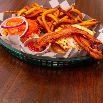 Bacon burger with fries and ketchup.