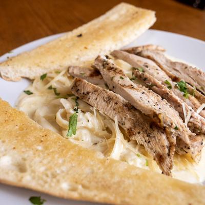 Fettuccini Alfredo with chicken and garlic bread.