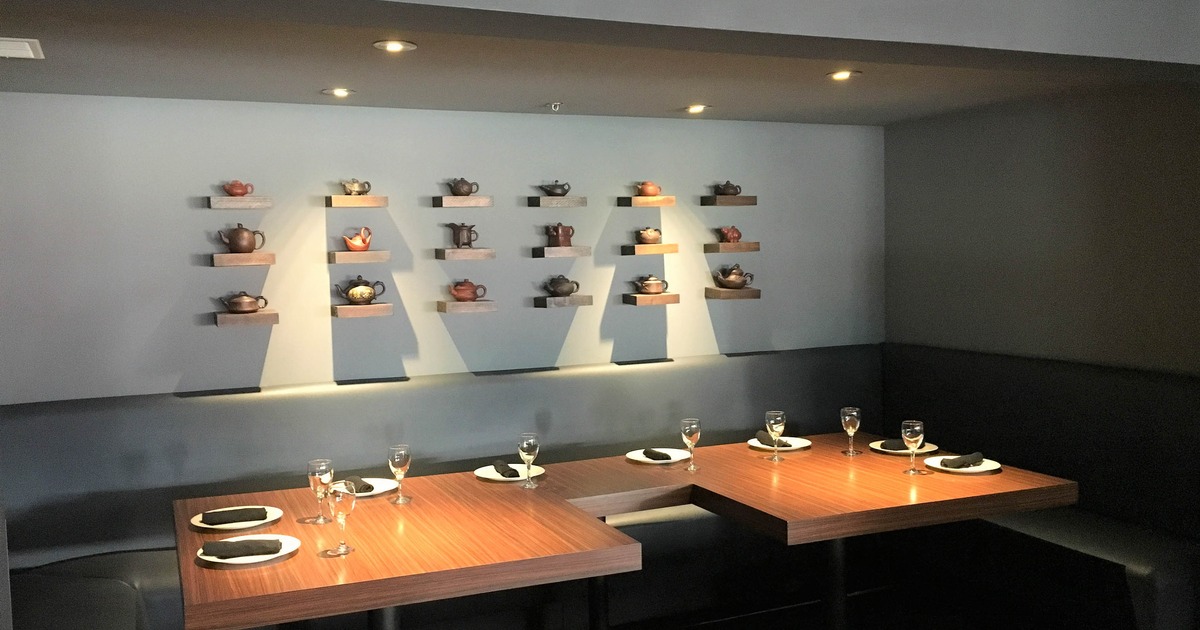 Dining area with various teapots on mounted wall shelves