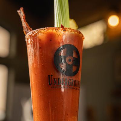 Bloody Mary cocktail garnished with celery and a bacon strip.