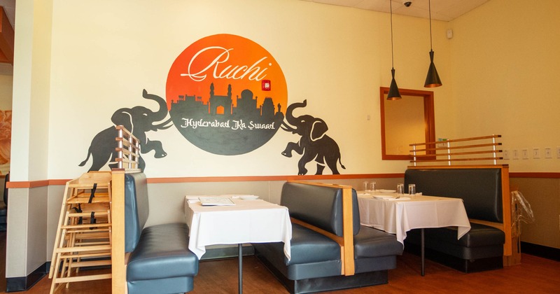 Interior, booths with plates and glasses with logo on the wall
