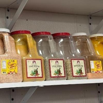 A shelf stocked with various spices in labeled jars