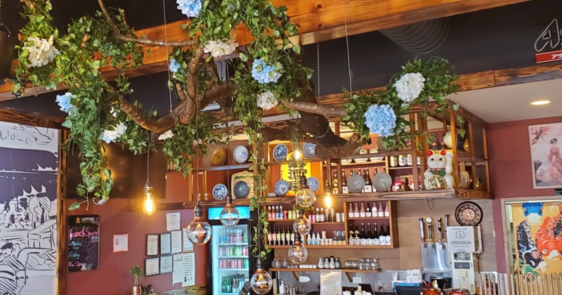 Interior, the decor features a large, decorative branch with artificial foliage and flowers