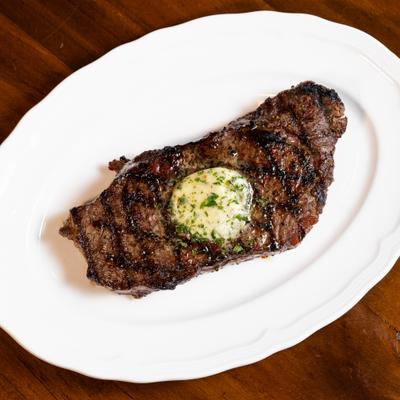 Prime Ribeye topped with herb butter.