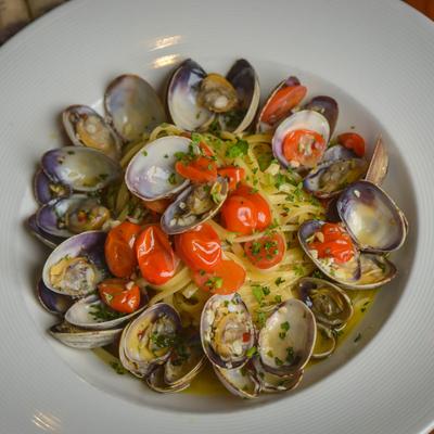 Linguine pasta served with clams and cherry tomatoes in a white wine sauce.