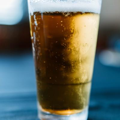 Golden beer with light foam in a pint glass.