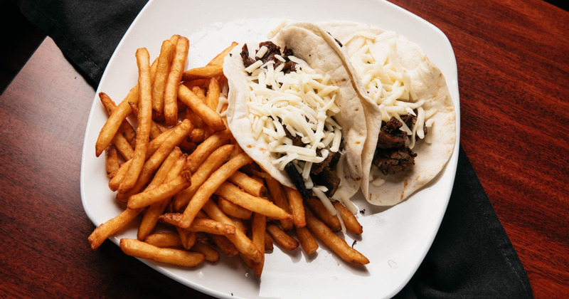 Flour tortilla tacos served with fries