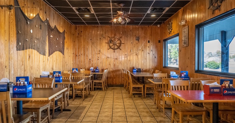 Interior, dining room, by window, with fishing net and rudder as details on the wall