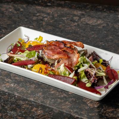 Salad with mixed greens, beets, oranges, and crispy prosciutto topping.