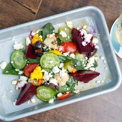 Beet salad with feta and cucumber served on a metal plate.