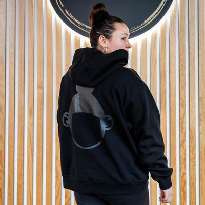 Woman in a black ''Hula Pot'' hoodie with logo, back view, closeup.