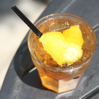 Translucent orange cocktail with an orange peel