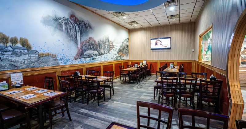 Interior, diner area, tables, chairs, wide view, screen on a wall behind