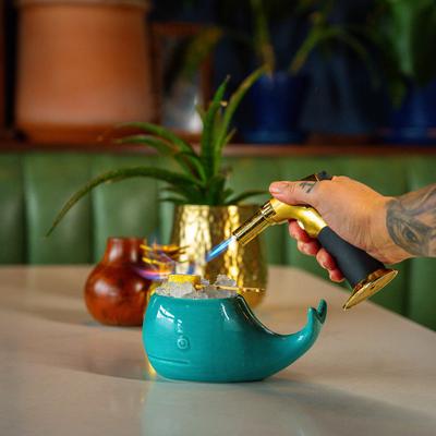 Person preparing drink in whale like glass.