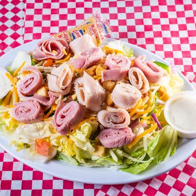 Salad with ham, turkey, onions, tomatoes and cheese, served with dip