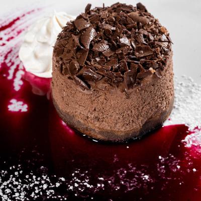 Chocolate Cremoso with whipped cream, powdered sugar, and raspberry reduction.