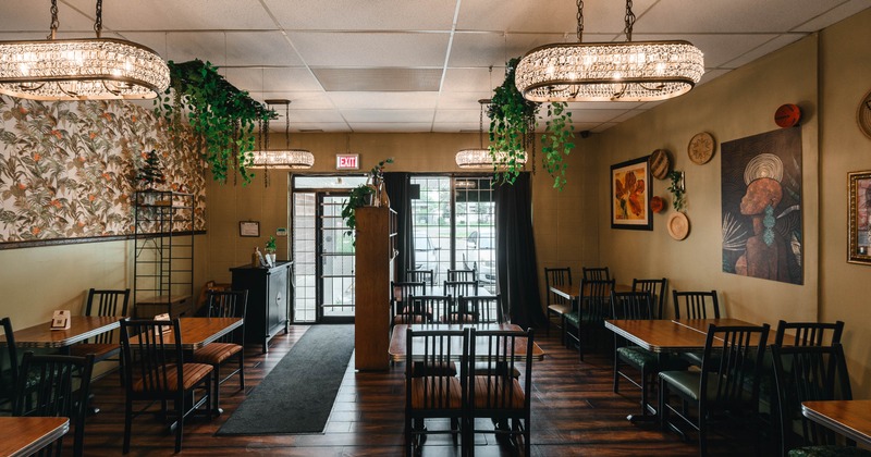 Interior, dining area,  tables for two and four, various paintings and wall decorations