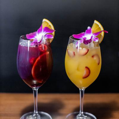 Two berry cocktails, a yellow and purple variant