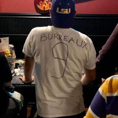 a guy in a hand made jersey from behind watching the game