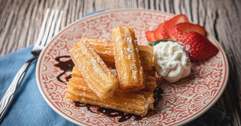 Churros, with whipped cream and strawberries