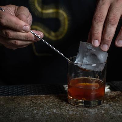 Hands preparing a cocktail.