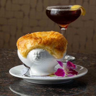 Mussel Bisque en Croûte served with a cocktail drink.