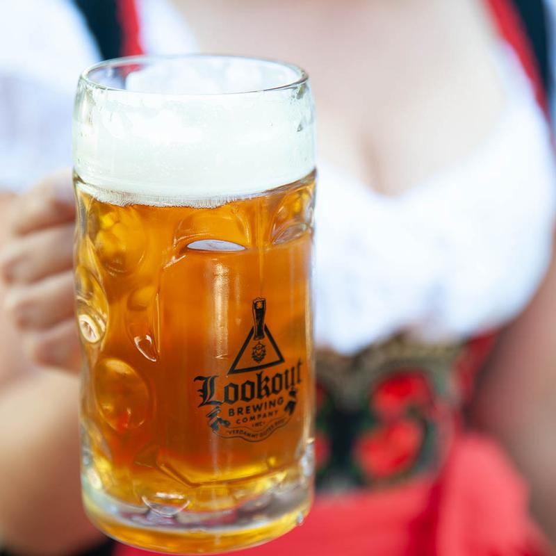 Person holding a branded mug filled with beer.