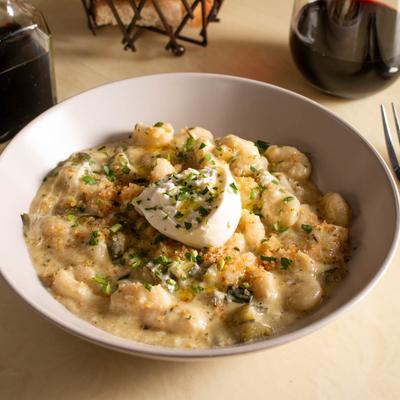 Potato gnocchi in pesto sauce with cherry tomato confit and burrata cheese.