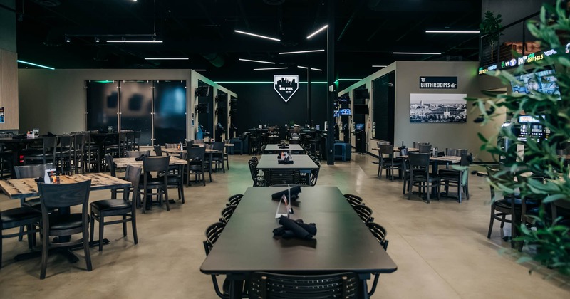 Interior, dining area, tables for six and four ready for guests, concrete flooring