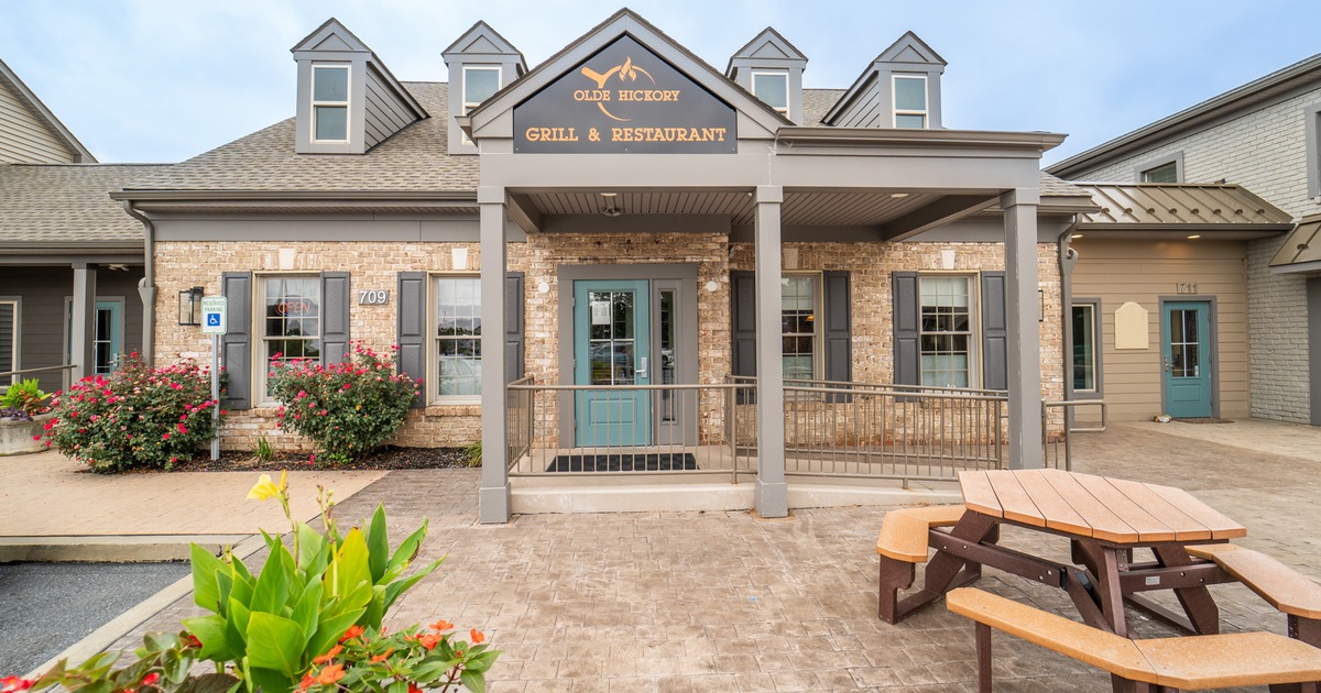 Front view to restaurant and yard in front, plant, benches, tables, porch  entrance