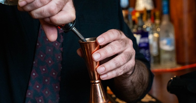 Hands preparing a cocktail