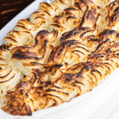 Shepherd pie topped with mashed potato, close-up.