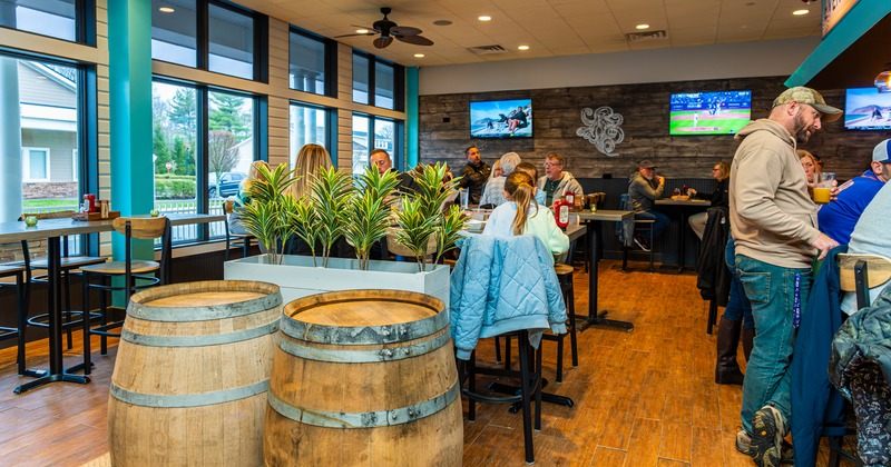 Interior, wide view to diner area, barrels , tables and chairs, bar behind