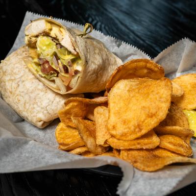 Honey mustard chicken wrap with a side of chips.