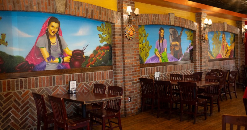 Restaurant interior, dining area with lined up dining tables, wall murals