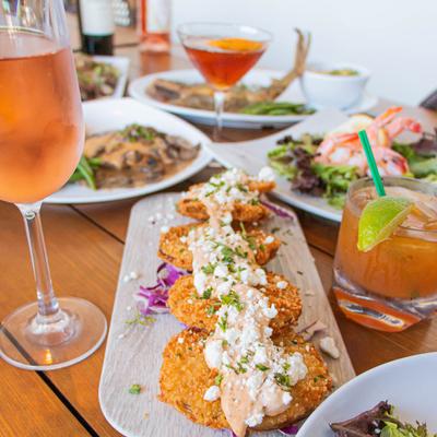 Crab cake plate with an assortment of dishes and drinks.