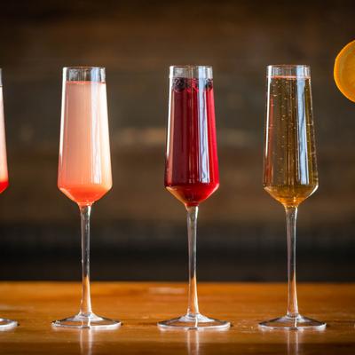 Assorted mimosas lined up on a table.