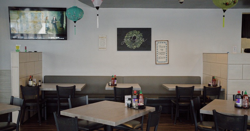 Interior of a restaurant with tables, chairs, hanging lanterns, and wall decorations