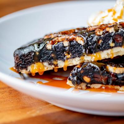 Brownie dessert with vanilla ice cream, caramel, and whipped cream.