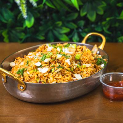 Indian-style spicy fried rice with cabbage, scallions, herbs, and chili sauce.