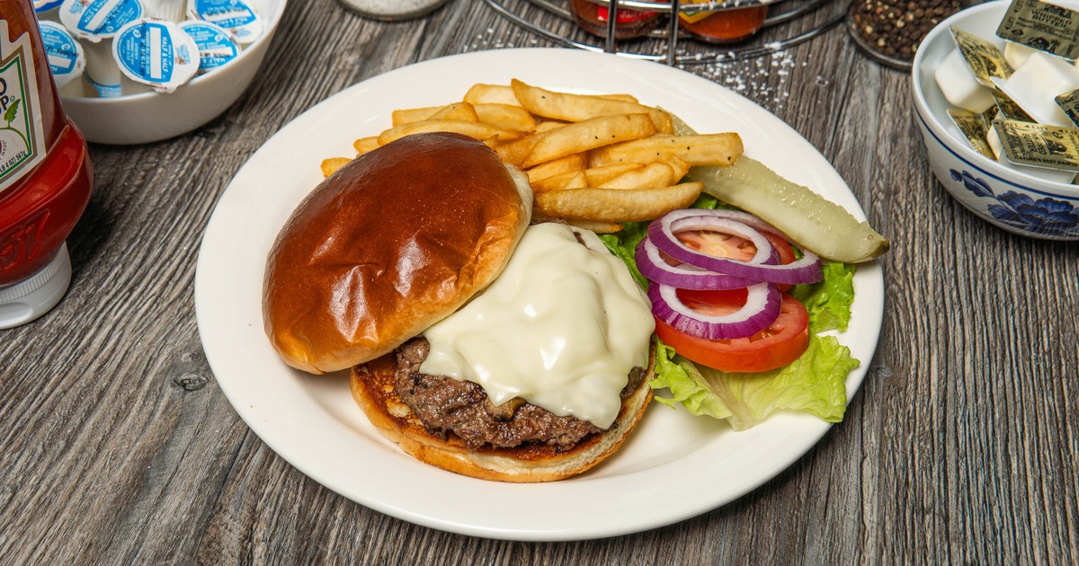 Mushroom Swiss burger served alongside seasoned fries