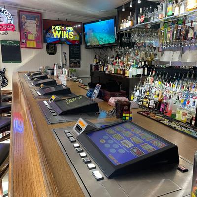 Interior, bar counter with arcade game machines.