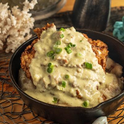 Fried Pork Chop over Southern mashed potatoes, topped with sausage gravy.