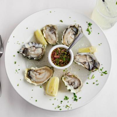 Oyster served with a sauce and lemon.