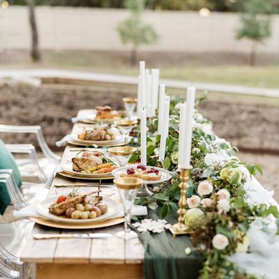Different dishes on a table decorated with candles and greenery, Christmas shoot