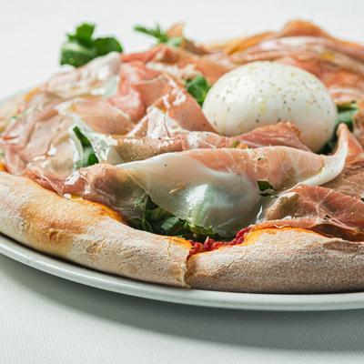 Pizza with San Marzano tomatoes, arugula, burrata cheese, and prosciutto.
