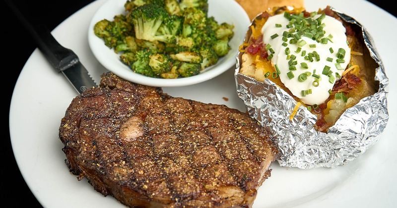 Grilled ribeye, served with broccoli and a baked potato